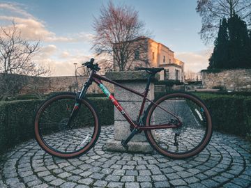 A modern black mountain bike with a pink trim